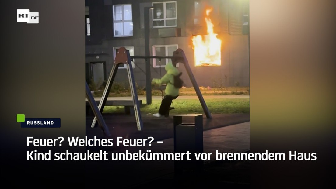 Feuer? Welches Feuer? – Kind schaukelt unbekümmert vor brennendem Haus