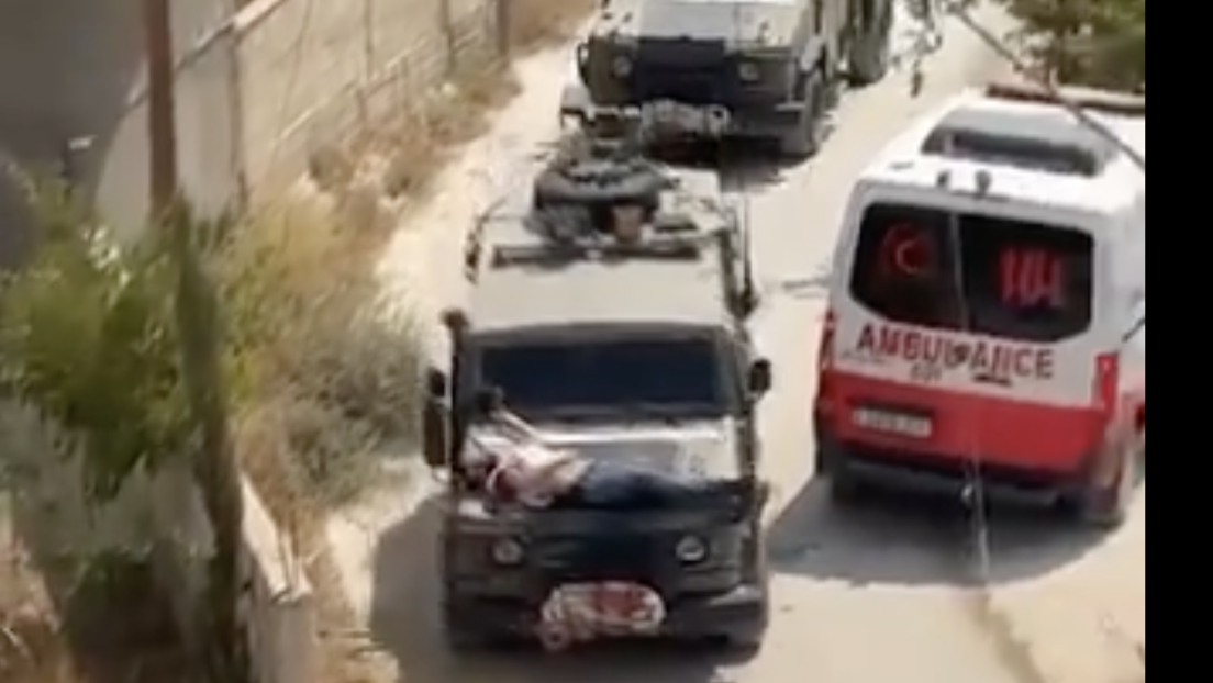 Israelische Soldaten binden verletzten Palästinenser auf ihren Jeep