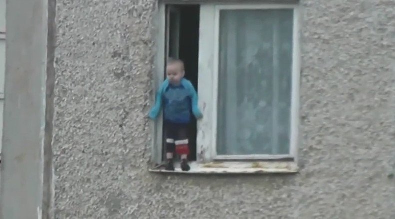 Worst parents ever? Russian toddler hangs out of 8th floor window (VIDEO)