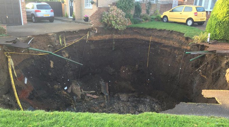 Massive sinkhole swallows suburban street, families evacuated 