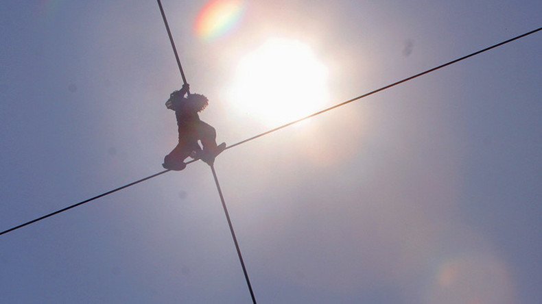 Soaring neighbor: Russian daredevil walks tightrope after laying 10-story-high wire (VIDEO)