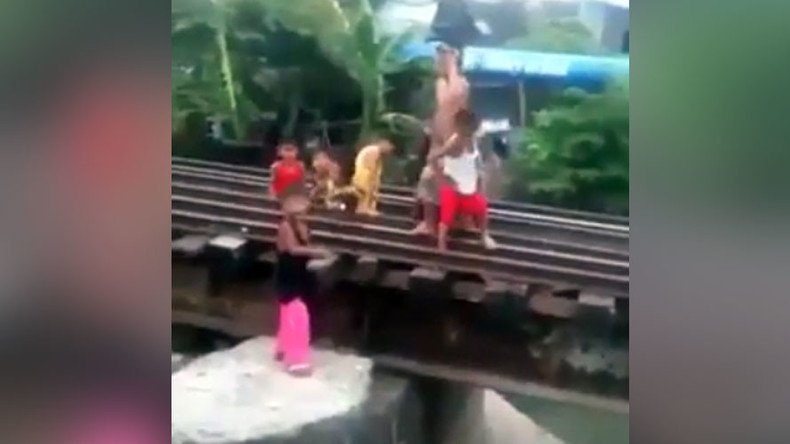 Kids at play dodge oncoming train by hiding beneath tracks (VIDEO)