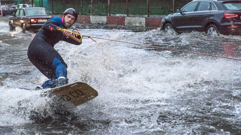 Watch man surf giant puddle on Moscow’s rainiest day ever (VIDEO)