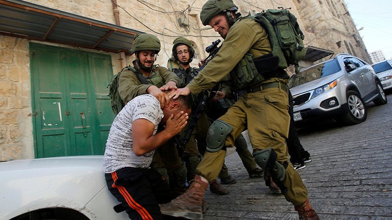 Israeli troops photographed beating unarmed Palestinian during 'routine check'