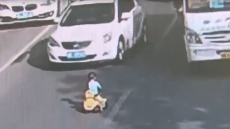 Toddler rides toy bike through rush hour traffic in China (VIDEO)