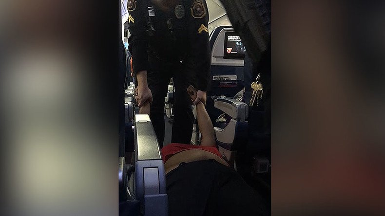 Woman dragged off flight by police for boarding plane too early (VIDEO)
