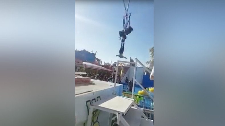Inches from disaster: Thrillseeker cheats death, dangles by ankles on fairground ride (VIDEO)