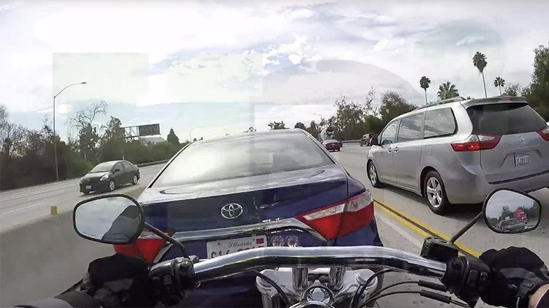 Biker lands on top of car after bizarre freeway collision (VIDEO)