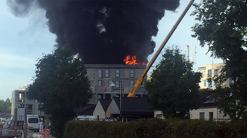 Man escapes burning building by holding on to crane hook (VIDEO) 