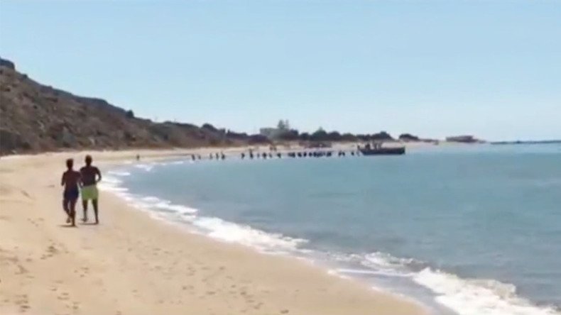 Migrants rush across Sicilian beach after dramatic boat landing (VIDEO)