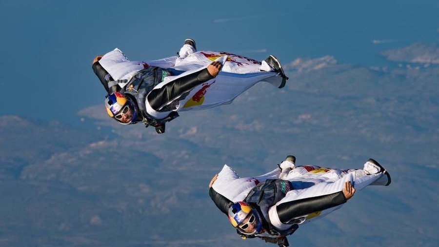 Wingsuit flyers jump off mountain & into moving plane in insane stunt (VIDEO)