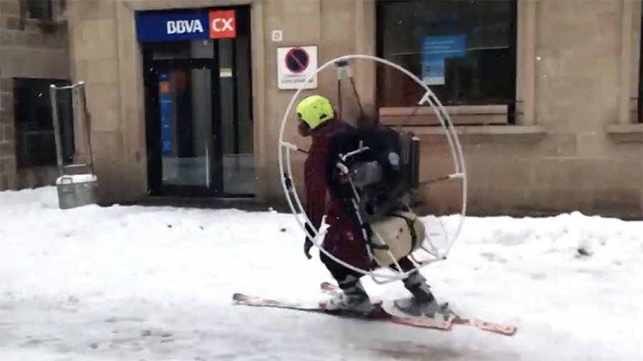 Paramotored skier takes to snowy Catalan streets as Europe is hit by freak blizzards (VIDEO)