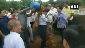 Indian politician & supporters drench engineer with mud in road protest (VIDEO)