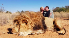 ‘Sick’ hunting couple slammed for smooching over corpse of dead lion 