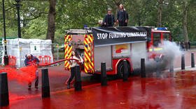 Tables turned: Extinction Rebellion activists lose control of ‘fake blood’ fire hose and douse themselves (VIDEO)
