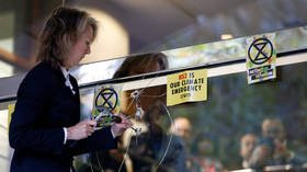 WATCH: Extinction Rebellion co-founder climbs UK govt building carrying hammer, as police ban XR protests from London