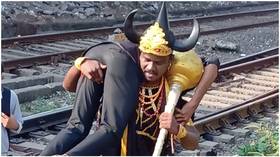Railway officials summon horned GOD OF DEATH to drag people off railway tracks in India (VIDEOS)
