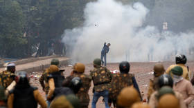 Tear gas fired as protesters hurl stones at police & damage cars in New Delhi in massive rally over citizenship bill (VIDEO)