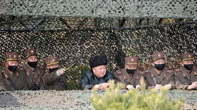 North Korea's Kim shows no panic appearing WITHOUT protective gear, surrounded by ALL-MASKED officers during military drills
