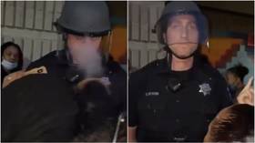 US cop stays calm as protesters blow smoke in his face & give him middle finger (VIDEO)