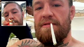 Living the high life: Fans watch ex-UFC champ McGregor toke HUGE roll-up on lounger as star enjoys retirement (VIDEO)