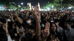 Thailand’s King calls for unity after protesters turn back on his motorcade & throw up ‘Hunger Games’ salute (VIDEOS, PHOTOS)