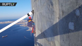 Watch as daring alpinist cleans 320m-high Russky Bridge after freak storm glazes it with ice (VIDEO)