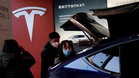 Visitors check a Tesla vehicle at a showroom in Beijing, China, January 2021. © Tingshu Wang / Reuters