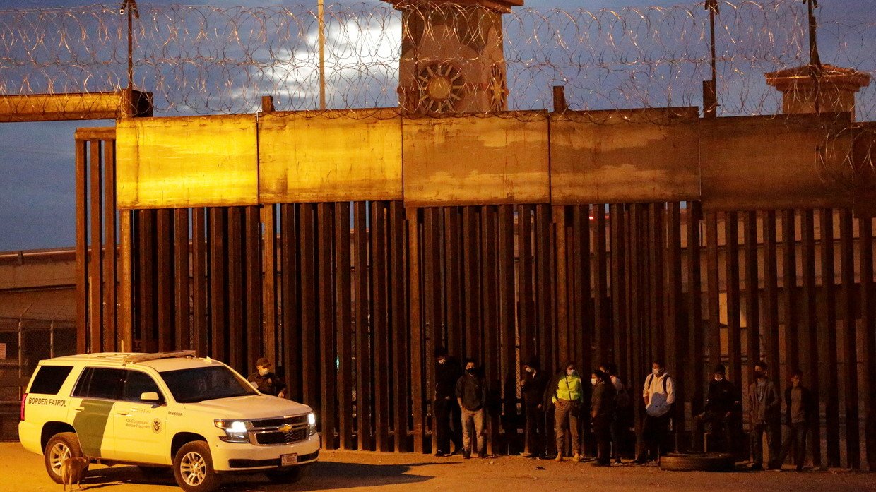FILE PHOTO: Migrants are detained by a US Border Patrol agent as they turn themselves in to request asylum, after crossing into El Paso, Texas, as seen from Ciudad Juarez, Mexico February 2, 2021.