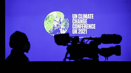 A cameraman sits in front of a screen displaying COP26 logo during a news conference at the UN Climate Change Conference (COP26), in Glasgow, Scotland, Britain, November 5, 2021. © REUTERS / Phil Noble