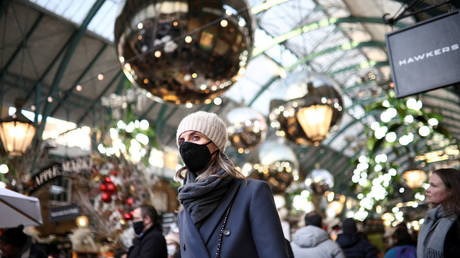 A person wearing a protective face mask walks through Covent Garden in London. © Reuters / Henry Nicholls