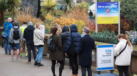 People queue outside a COVID-19 vaccination center at St Thomas's Hospital in London. December 13, 2021. © Reuters / Hannah McKay