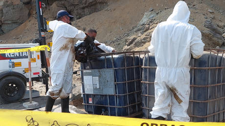 Cleaning crews remove oil from a beach in Callao Region, Peru, January 19, 2022. © Carlos Mandujano/AFP