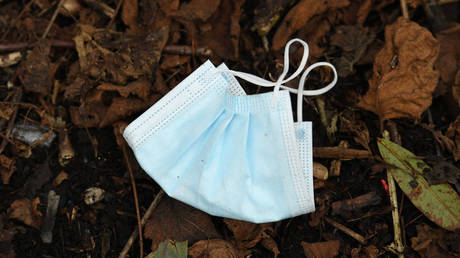 A discarded facemask lies on the ground. © AFP / Oli Scarff