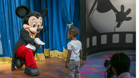 FILE PHOTO: An actor portraying Mickey Mouse poses for photos with visitors at Walt Disney World Resort in Lake Buena Vista, Florida, April 18, 2022 © AP / Ted Shaffrey