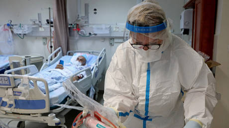 A hospital worker tends to a Covid-19 patient in Ashkelon, Israel, February 2022. © Gil Cohen-Magen / AFP