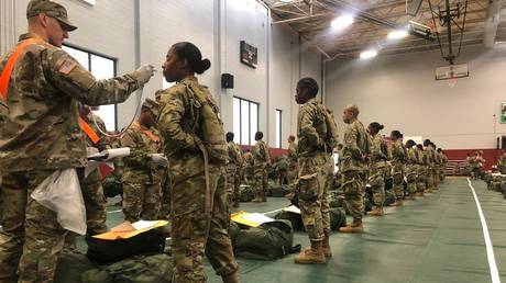 FILE PHOTO: Army basic combat training graduates have their temperatures taken as they arrive at Fort Lee, Va, March 31, 2020