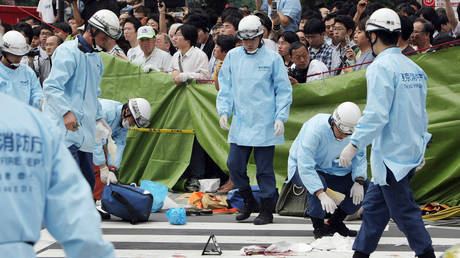 FILE PHOTO. Rescue workers gather at the site where Tomohiro Kato went on a stabbing spree in Tokyo's Akihabara electronic shops street on June 8, 2008.