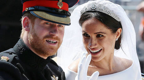 Britain's Prince Harry, Duke of Sussex and his wife Meghan, Duchess of Sussex wave from the Ascot Landau Carriage after their wedding ceremony.