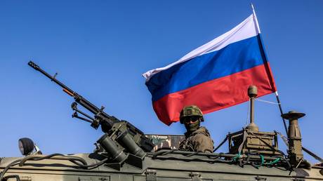 FILE PHOTO: Russian soldiers, with Russian flag, are seen on armoured vehicle as they enter the base at the Tishrin Dam on the Euphrates in Aleppo Governorate, Syria.