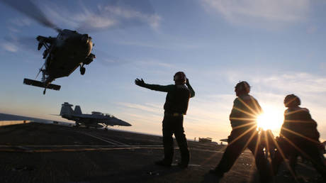 FILE PHOTO: A US Navy helicopter is shown taking off from the flight deck of the USS Nimitz as the aircraft carrier conducts training operations in January 2020.