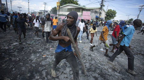 A protester carries a wooden stick during a demonstration demanding the resignation of Prime Minister Ariel Henry, in Port-au-Prince, Haiti, October 3, 2022.