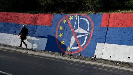 A pedestrian walks past an anti-EU and anti-NATO mural painting in Belgrade, Serbia, April 2, 2022