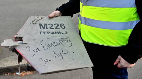 FILE PHOTO. A police expert in Kiev holds a fragment of a drone with a handwritten inscription reading "For Belgorod. For Luch"