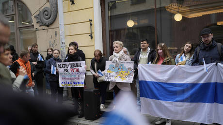 Demonstrators show banners and flags during a protest near the Russian embassy in Tallinn, Estonia, October 15, 2022