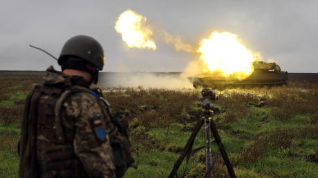 A Ukrainian soldier watches as a Gvozdika self-propelled howitzer fires a shell on the front line in Donetsk region.
