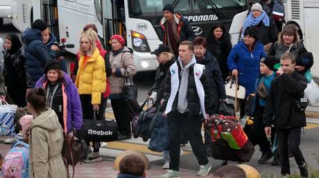 FILE PHOTO: Evacuees from the Kherson region leave a bus near a railway station in Dzhankoy, Crimea, on October 21, 2022.