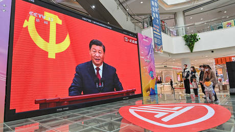 People watch a live broadcast of China's President Xi Jinping speaking during the introduction of the Communist Party of China's Politburo Standing Committee.