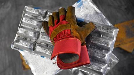 A worker's gloves rest on aluminum ingots in the foundry of the Rusal Krasnoyarsk aluminum smelter in Krasnoyarsk, Russia.