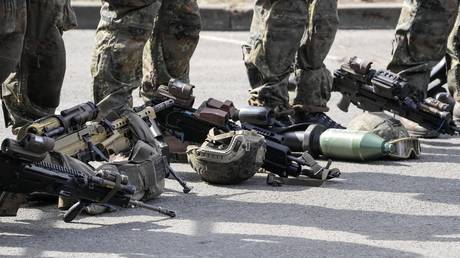 German soldiers stand behind their battle gear at Field Marshal Rommel Barracks in Augustdorf, Germany, March 30, 2022